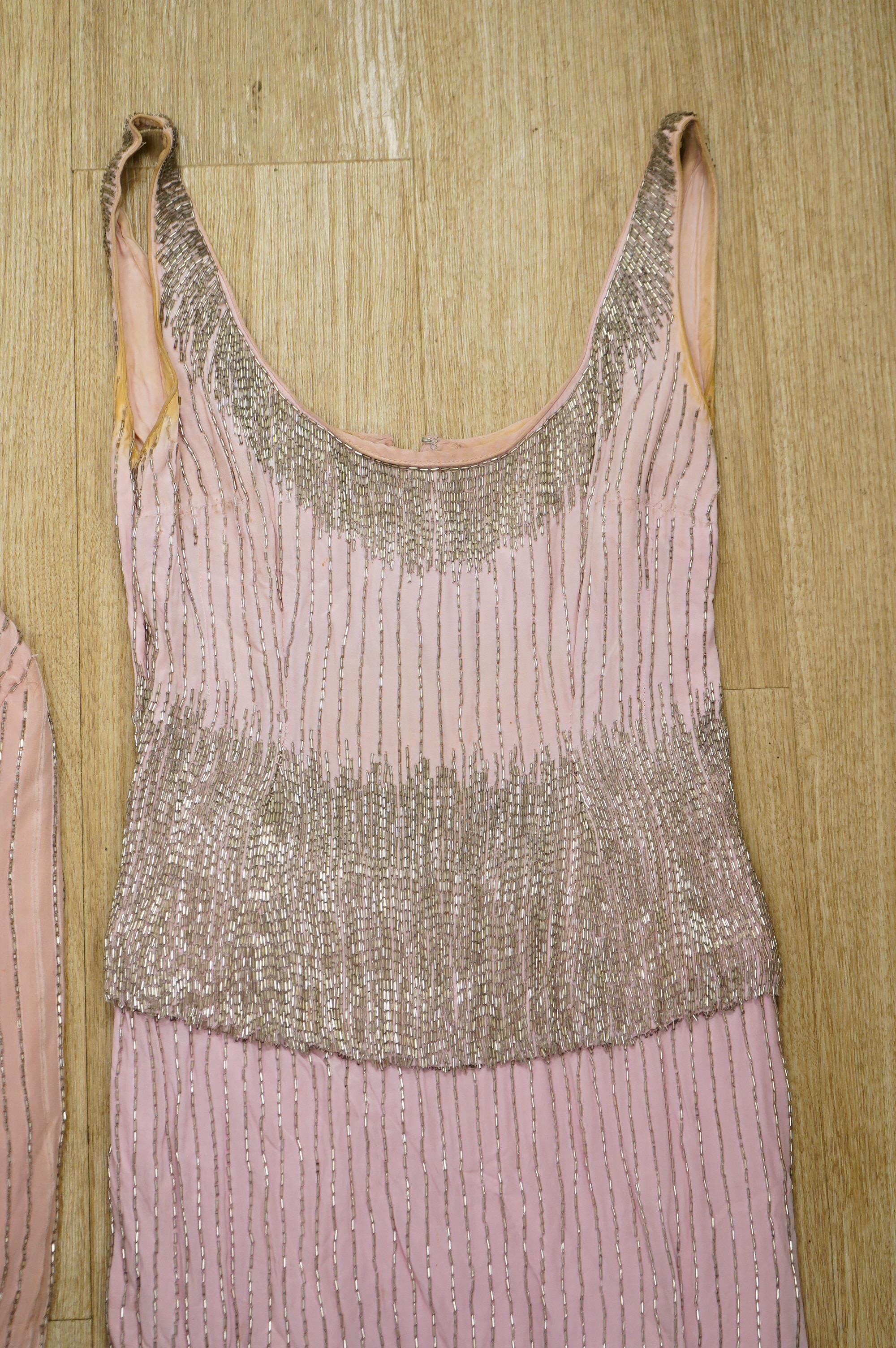 A mid to late 20th century pink and silver beaded evening dress-120cm long, with matching jacket, together with a green net beaded full length evening dress with mushroom lining and back split.